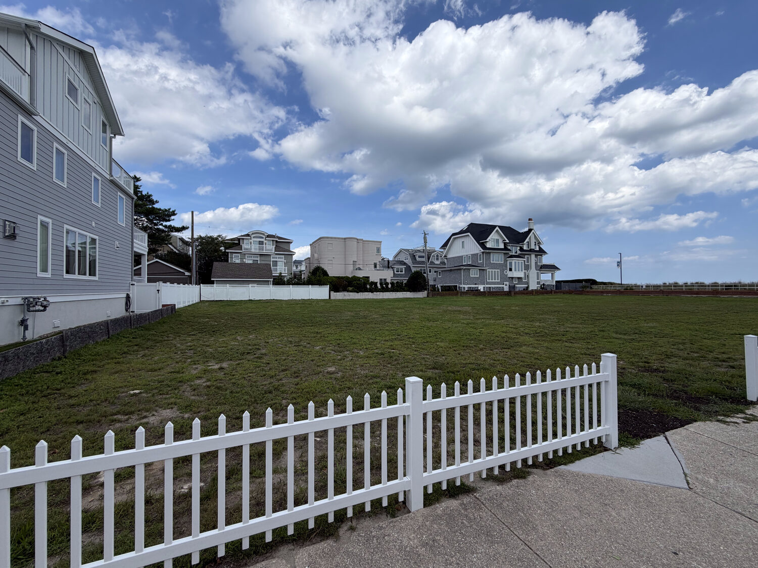 Lot with neighboring homes and picket fence
